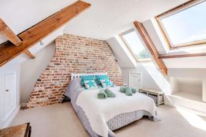 a bedroom with a bed with a brick wall at Passiflora Cottage Close to Swanage Beach and Town Sleeps 7 in Swanage +23 photos