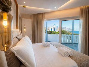 a bedroom with a bed with a view of the ocean at Vista Maris Suites in Amoopi