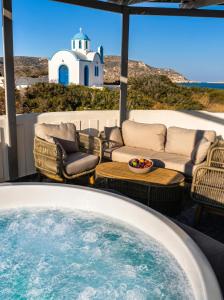 a hot tub on a patio with a view of a lighthouse at Vista Maris Suites in Amoopi
