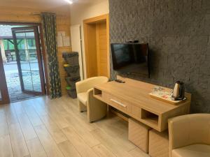 a living room with a tv and a table with chairs at Pod Grzybkiem in Zawady