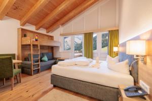 a bedroom with a bed and a desk and a chair at Familotel Kaiserhof - Families only in Berwang +92 photos
