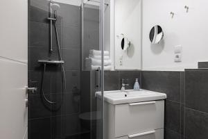 a bathroom with a shower and a sink and a mirror at Davin City Aparments - Self-Check-In in Hamburg