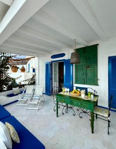 a living room with blue cabinets and a green table at Casa Prete in Panarea