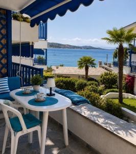 a table and chairs on a balcony with a view of the ocean at Brilliance Sea View Apartments in Ouranoupoli