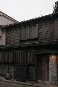 an old wooden building with a gate and a door at Haku-ma 白間 in Kanazawa