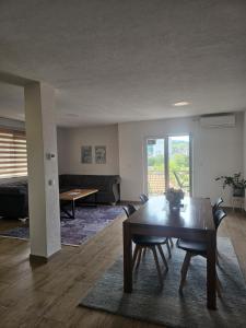 a living room with a dining room table and a couch at Apartmani ELEGANCE Tuzla in Tuzla