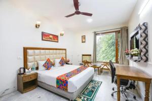 a hotel room with a bed and a desk and a window at FabHotel The Lalit Vibes - Nr DLF Phase 2 & MG Road Metro in Gurgaon
