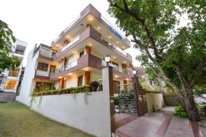 a large house with a white wall at FabHotel The Lalit Vibes - Nr DLF Phase 2 & MG Road Metro in Gurgaon