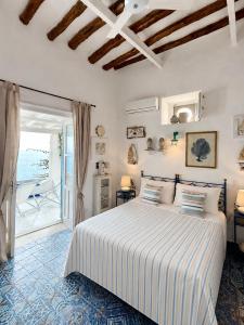 a bedroom with a bed and a door to a patio at Casa Prete in Panarea
