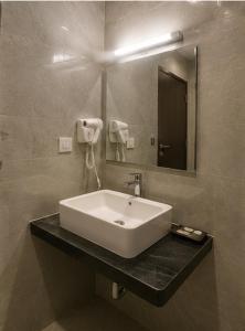 ein Badezimmer mit Waschbecken und Spiegel in der Unterkunft Hotel Smart Snap Sector 104, Noida in Noida