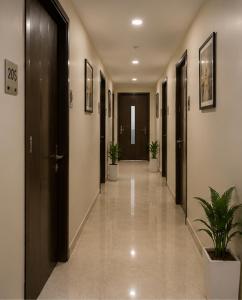 ein Flur mit Türen und Topfpflanzen in einem Gebäude in der Unterkunft Hotel Smart Snap Sector 104, Noida in Noida