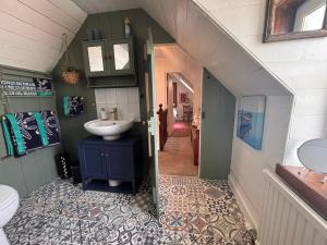 a small bathroom with a sink and a hallway at Loch Ness village cottage for 2 with free parking & pets welcome in Drumnadrochit +31 photos