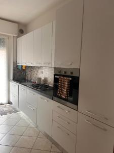 a kitchen with white cabinets and a stove top oven at Casa dei Navigatori in Verona