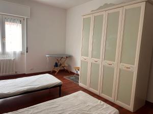 a bedroom with two beds and a large white cabinet at Casa dei Navigatori in Verona