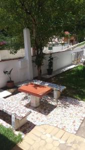 a picnic table sitting on a patio under a tree at Hotel Madrid in Mendes +23 photos