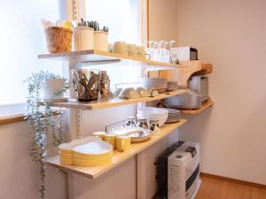 a kitchen with wooden shelves filled with dishes at みどりの風 -那須高原中心地-森を感じる貸切一軒家-観光や買い物に便利-無料bbq-最大7名-子供歓迎 in Nasu
