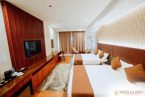 a hotel room with two beds and a television at Hotel La Vista by Grotto Vista in Mangangpico
