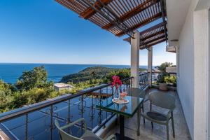 a balcony with a table and chairs and the ocean at Apartments Oktopus in Sutomore +177 photos
