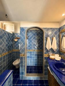 a blue tiled bathroom with a shower and a sink at Casa Prete in Panarea