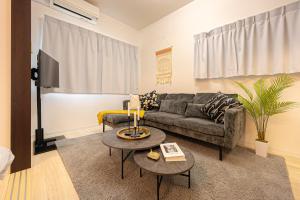 a living room with a couch and a table at Otter Stay - Masaki in Nagoya