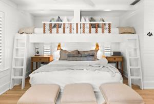a bedroom with white bunk beds and two tables at Luv U Honey in Santa Rosa Beach +49 photos