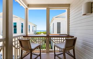 a balcony with two chairs and a view of the ocean at Luv U Honey in Santa Rosa Beach