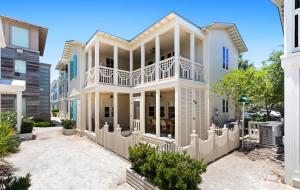 a large white house with a white fence at Luv U Honey in Santa Rosa Beach