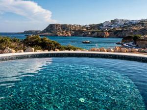 a swimming pool with a view of the ocean at Vista Maris Suites in Amoopi