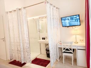 a bathroom with a sink and a desk and a shower at Pension am Wienfluss in Vienna