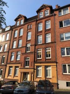 a brick building with cars parked in front of it at Stylischer Altbau im Zentrum in Kiel