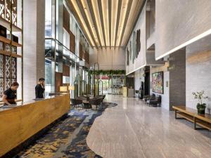 a lobby of a building with people sitting at a counter at Mercure Jakarta Gatot Subroto in Jakarta +230 photos