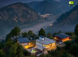 a house on a hill with a view of a river at Pacific Inn Vistaar Hotels & Resorts in Chamba