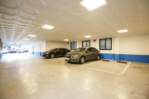 two cars parked in a parking lot in a garage at NU Hotel in Cheonan
