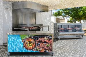 a bbq grill with a sign that says bbq day at Apartamentos Vibra Riviera in San Antonio Bay +43 photos