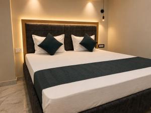 a bedroom with a large bed with green and white pillows at Hotel Bhagirath Palace in Ahraurā Road