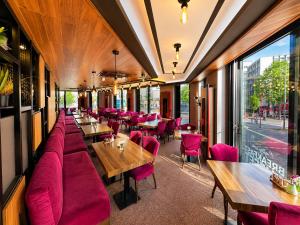 a restaurant with pink furniture and tables and a window at Nivara Hotel in Hamburg