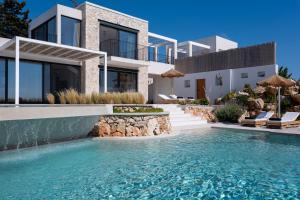 a villa with a swimming pool in front of a house at NeRó Villas Lefkada in Tsoukalades