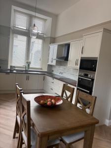 a kitchen with a table with a bowl of fruit on it at The Old Bank in Warrenpoint
