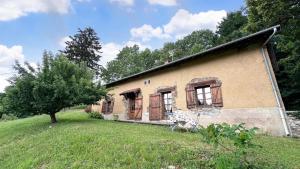 an old brick house with a tree in the yard at Sous les serves in Saint-Léonard-de-Noblat