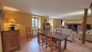 a kitchen and living room with a table and chairs at Sous les serves in Saint-Léonard-de-Noblat