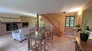 a dining room with a table and a fireplace at Sous les serves in Saint-Léonard-de-Noblat