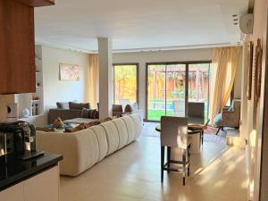 a living room with a large couch and a table at Villa avec Piscine Chauffée Privée pour Familles in Marrakesh
