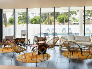 a lobby with chairs and tables and a pool at ibis Styles Arcachon Gujan Mestras in Gujan-Mestras