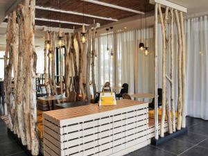 a store with a counter in a room with trees at ibis Styles Arcachon Gujan Mestras in Gujan-Mestras