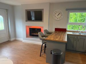 a kitchen with a fireplace and a clock on the wall at Doherty,s Chalet in Doon