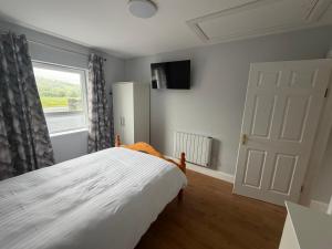 a bedroom with a white bed and a window at Doherty,s Chalet in Doon