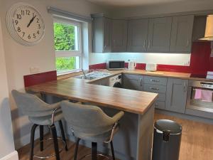 a kitchen with a wooden counter and a clock on the wall at Doherty,s Chalet in Doon