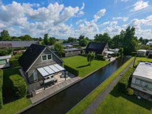 an aerial view of a house and a river at De Sloothaak in Giethoorn