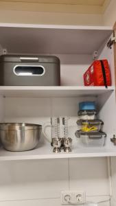 a kitchen shelf with a pan and other kitchen items at Indische kamer in Bolsward