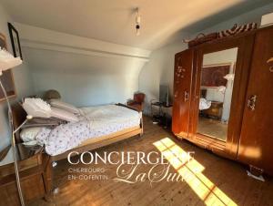 a bedroom with a bed and a dresser and a mirror at Le Nid du Matelot in Saint-Vaast-la-Hougue